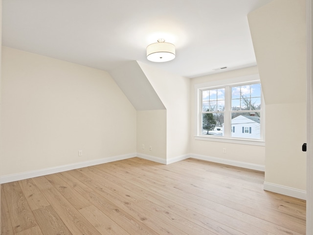 bonus room with light hardwood / wood-style floors and lofted ceiling