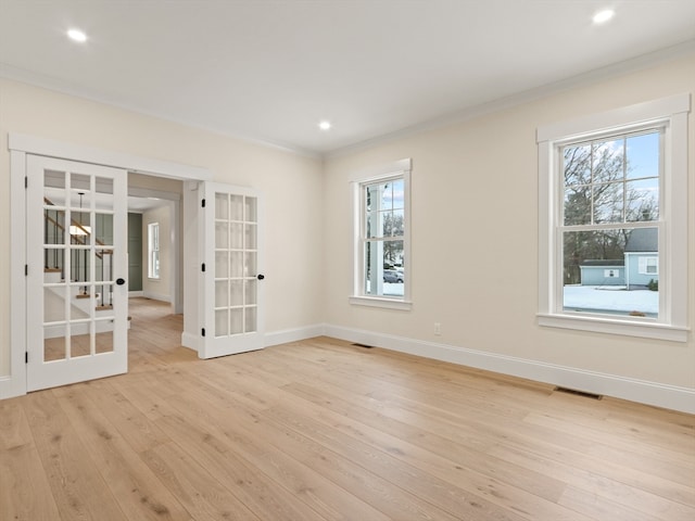 spare room with french doors, light hardwood / wood-style floors, and crown molding