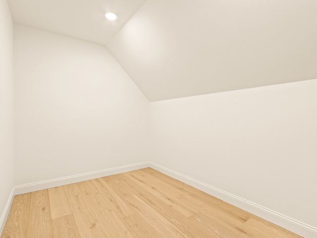 bonus room with wood-type flooring and vaulted ceiling