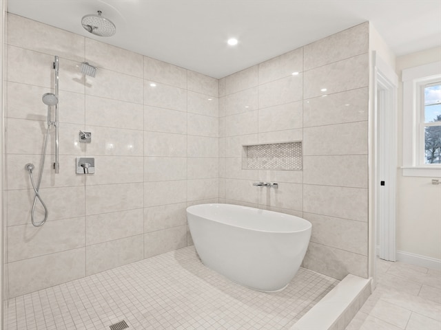 bathroom with tile patterned flooring, a tile shower, and tile walls