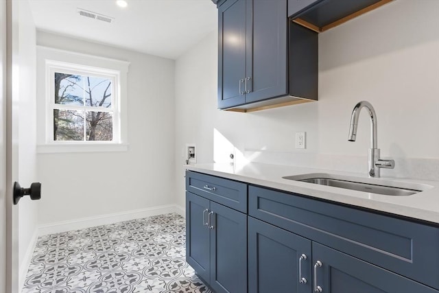 washroom with hookup for a washing machine, sink, light tile patterned floors, and cabinets