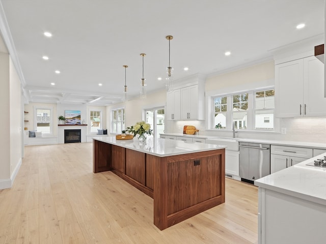 kitchen featuring dishwasher, hanging light fixtures, a spacious island, light hardwood / wood-style floors, and white cabinets