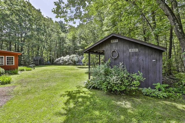 589 Turnpike, Ashby, MA 01431 - view of green lawn featuring a trampoline, a view of trees, and an outbuilding
