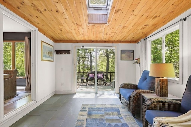 sunroom featuring tile patterned flooring, healthy amount of natural light, wood ceiling, and a skylight