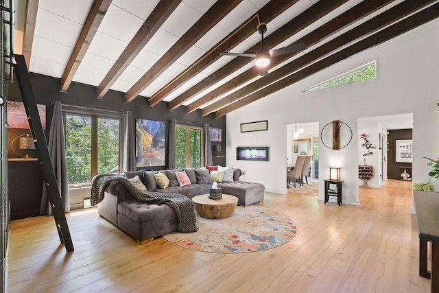 living area featuring beam ceiling, hardwood / wood-style flooring, high vaulted ceiling, and a ceiling fan