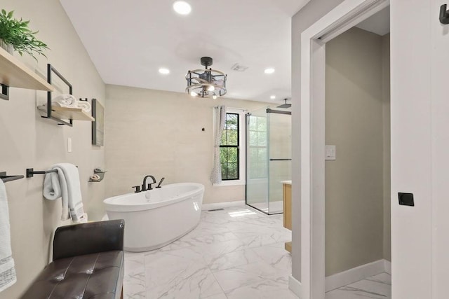 bathroom featuring marble finish flooring, a shower stall, baseboards, a freestanding tub, and recessed lighting