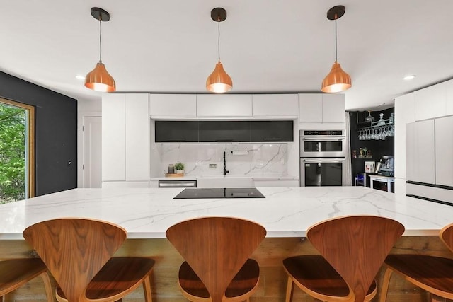 kitchen featuring modern cabinets, stainless steel double oven, decorative backsplash, a sink, and recessed lighting