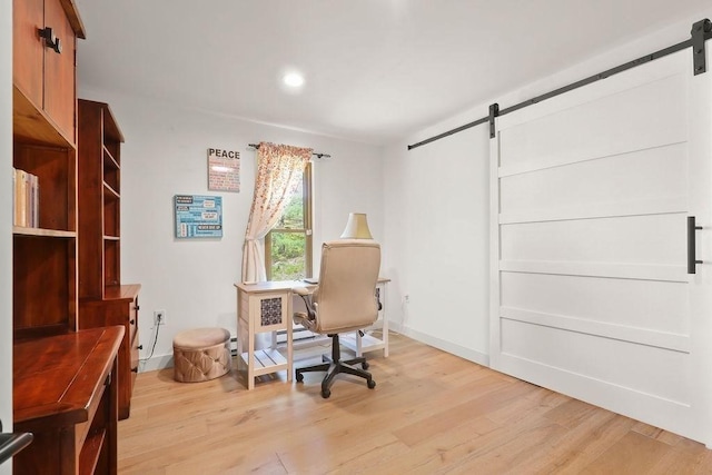 office area with a barn door, light wood finished floors, recessed lighting, and baseboards
