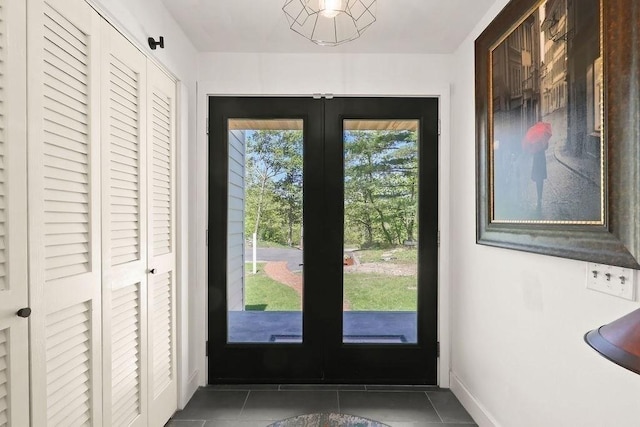 entryway with french doors, tile patterned floors, and baseboards