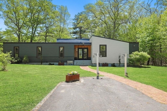 mid-century home featuring french doors, a front yard, and entry steps