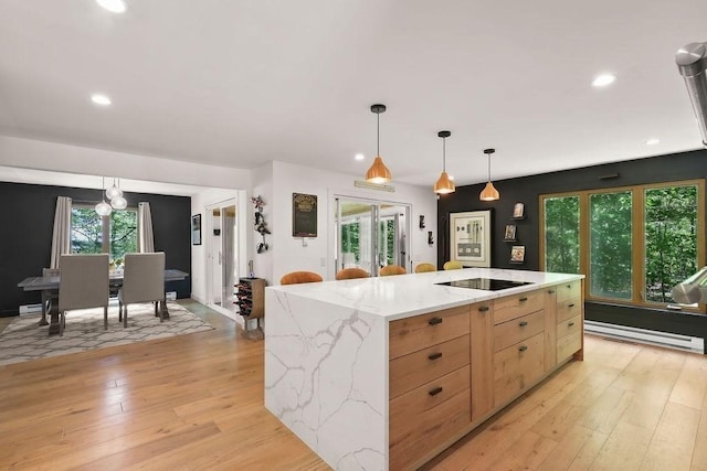 kitchen with light brown cabinetry, light wood-style flooring, decorative light fixtures, light stone countertops, and recessed lighting