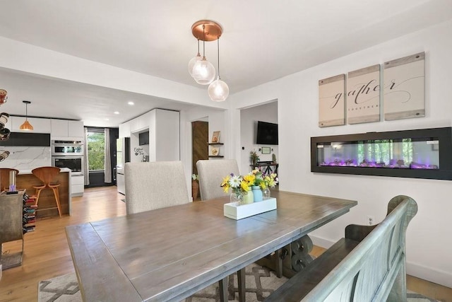 dining space featuring light wood finished floors and recessed lighting