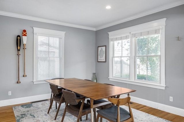 dining room with baseboards, crown molding, plenty of natural light, and wood finished floors