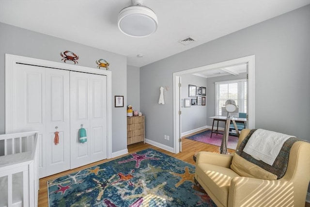 living area with visible vents, wood finished floors, and baseboards