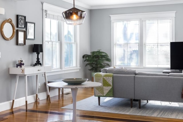 living room with crown molding, baseboards, and wood finished floors