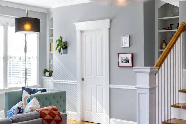 interior space featuring crown molding, built in shelves, and baseboards