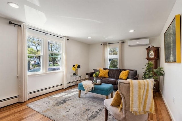 living area with plenty of natural light, a wall mounted AC, and wood finished floors