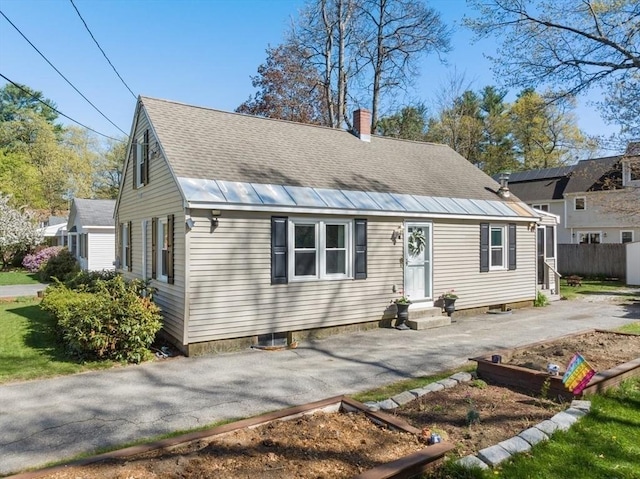 view of front of home with aphalt driveway, fence, a chimney, a shingled roof, and entry steps