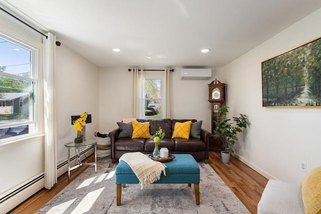 living room with a wall mounted AC, a baseboard heating unit, recessed lighting, and wood finished floors