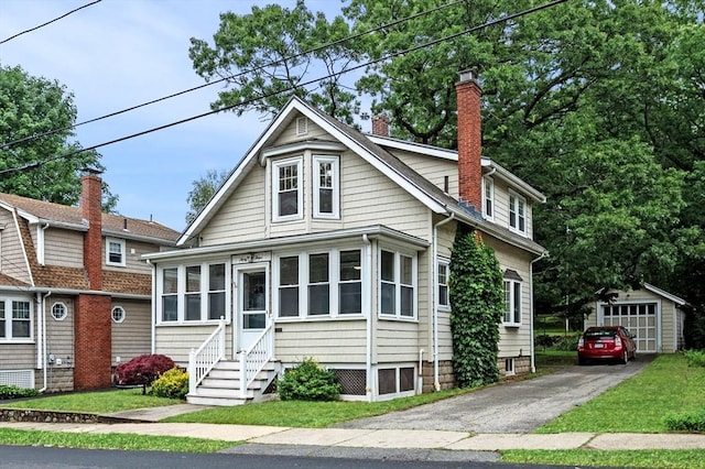 33 Intervale Ave, Saugus, MA 01906 - view of front of house with a chimney, entry steps, an outbuilding, asphalt driveway, and a garage