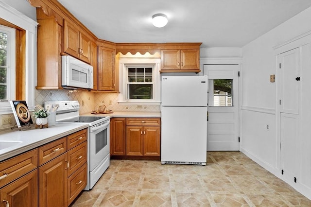 33 Intervale Ave, Saugus, MA 01906 - kitchen with white appliances, brown cabinets, backsplash, and light countertops