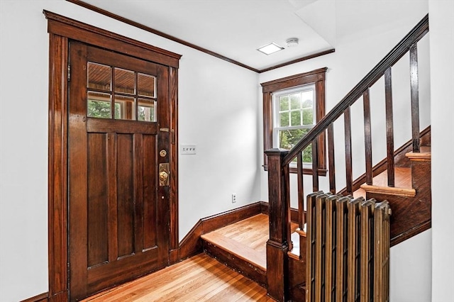 33 Intervale Ave, Saugus, MA 01906 - entrance foyer featuring light wood finished floors, stairway, ornamental molding, and radiator