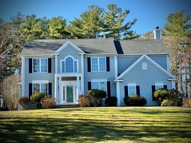 colonial-style house featuring a front yard