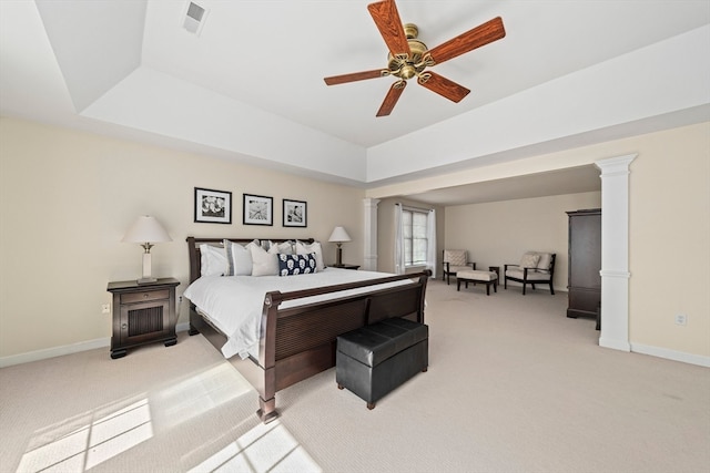 bedroom featuring light carpet, decorative columns, a raised ceiling, and ceiling fan