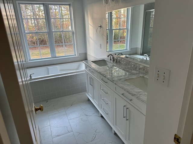 bathroom featuring vanity, tiled bath, and plenty of natural light