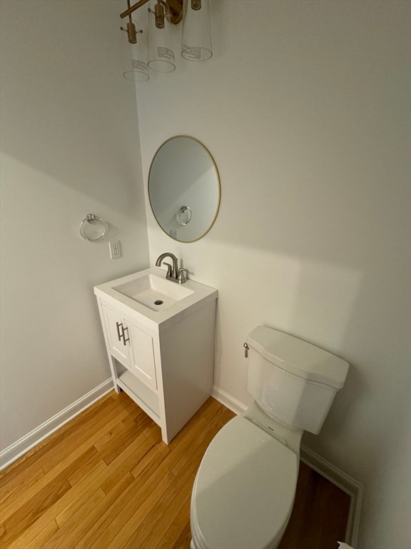 bathroom featuring wood-type flooring, vanity, and toilet