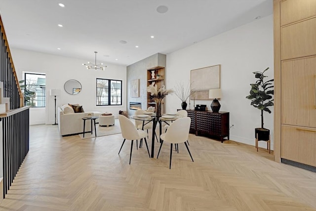 dining space featuring a large fireplace, baseboards, an inviting chandelier, stairs, and recessed lighting