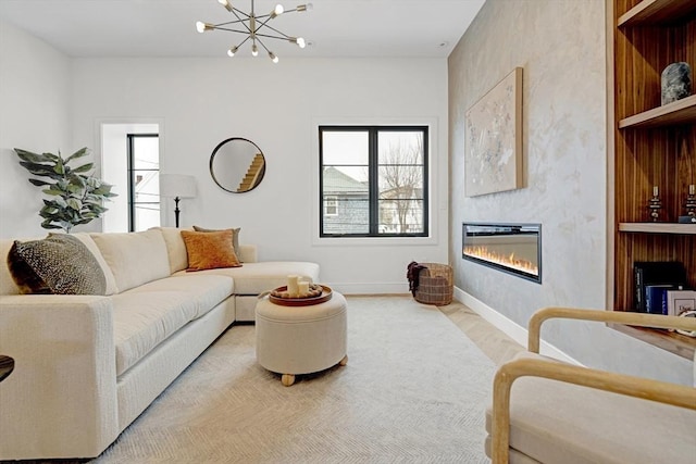 living area with a glass covered fireplace, baseboards, and an inviting chandelier