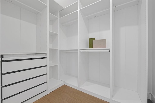 walk in closet with wood finished floors