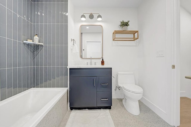 bathroom featuring toilet, tiled shower / bath, baseboards, and vanity