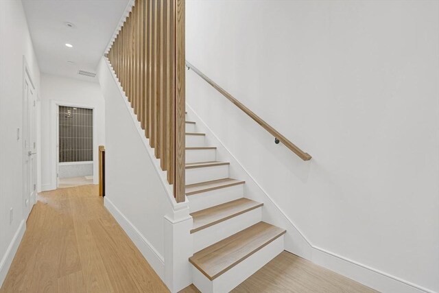 stairs with recessed lighting, visible vents, baseboards, and wood finished floors