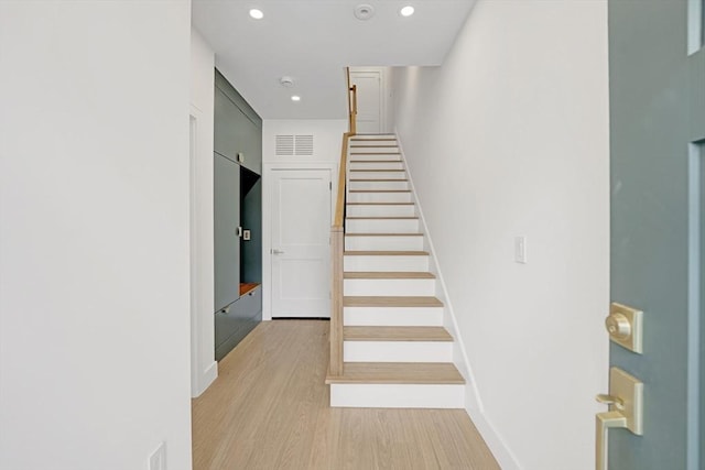 stairs with recessed lighting, visible vents, baseboards, and wood finished floors