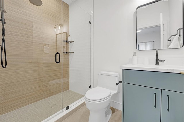 bathroom featuring toilet, a shower stall, and vanity