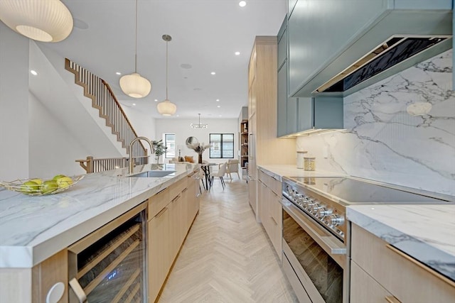 kitchen with beverage cooler, light stone counters, a sink, and stainless steel stove