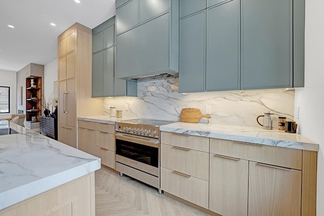 kitchen with decorative backsplash, modern cabinets, light stone counters, light brown cabinetry, and stainless steel range with electric stovetop