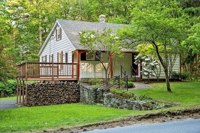 39 Mashapaug Rd, Sturbridge, MA 01566 - view of front of property featuring roof with shingles, a chimney, a front lawn, and a deck