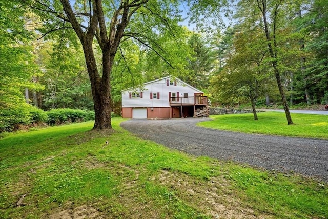 39 Mashapaug Rd, Sturbridge, MA 01566 - view of front of home with a deck, driveway, an attached garage, and a front lawn