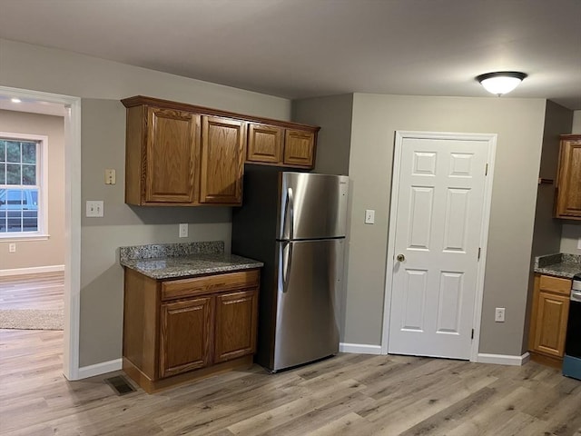 48 N Main St, New Salem, MA 01355 - kitchen with freestanding refrigerator, light wood-style flooring, brown cabinets, and baseboards