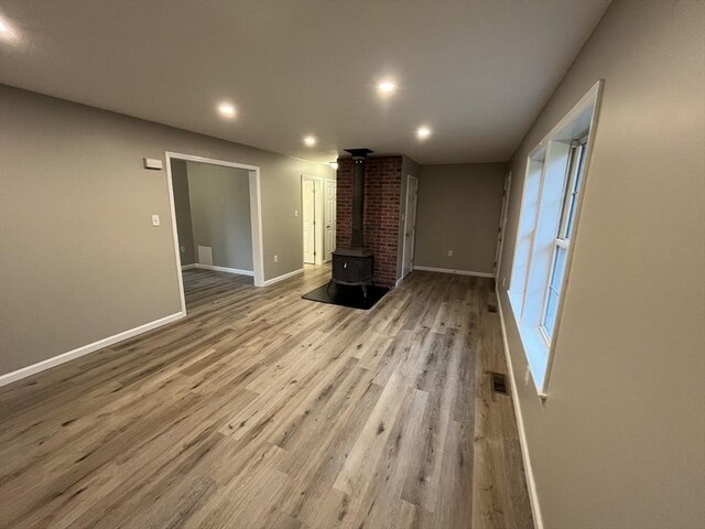 48 N Main St, New Salem, MA 01355 - unfurnished living room featuring a wood stove, wood finished floors, recessed lighting, and baseboards