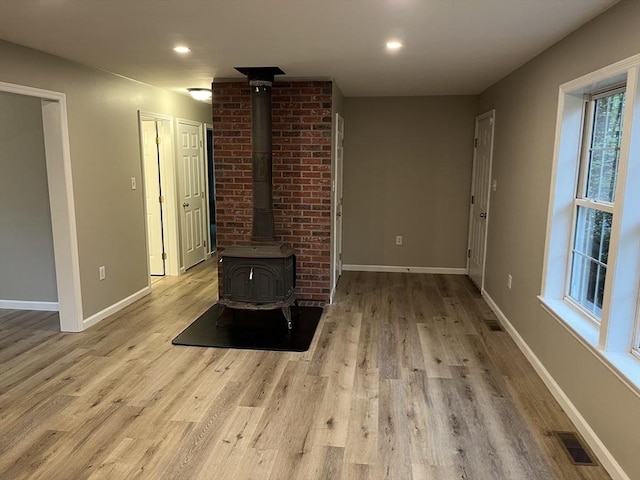 48 N Main St, New Salem, MA 01355 - unfurnished living room featuring a wood stove, wood finished floors, baseboards, and recessed lighting
