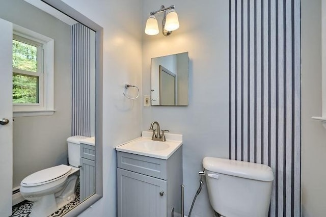 bathroom featuring toilet, vanity, and baseboard heating