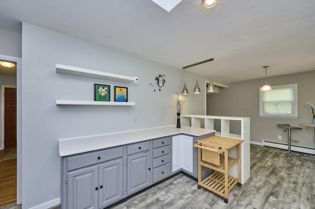 kitchen with a baseboard heating unit, light wood-type flooring, gray cabinetry, and open shelves