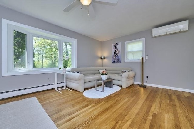 living room with a wall mounted AC, healthy amount of natural light, a baseboard heating unit, and wood finished floors