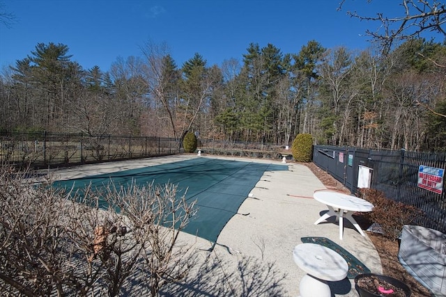 pool with a patio and fence