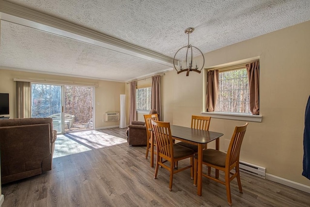 dining space featuring wood finished floors, baseboards, a wall mounted air conditioner, a textured ceiling, and a chandelier