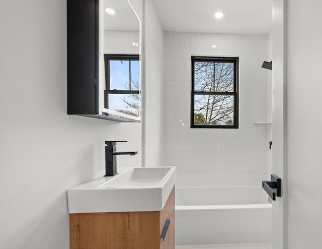 bathroom with vanity, recessed lighting, a healthy amount of sunlight, and shower / washtub combination